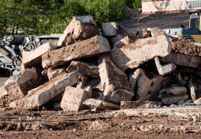 Pile of large concrete rubble at a demolition site.