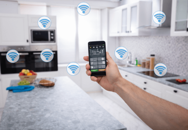 New-Kitchen A person using a smartphone to control various smart home devices in a modern kitchen.